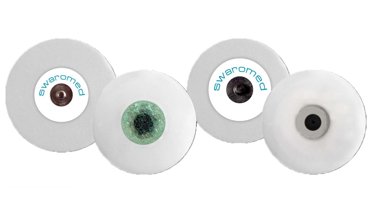 Fire hvide elektroder med forskellige centre og teksten "swaromed" trykt på to af dem.