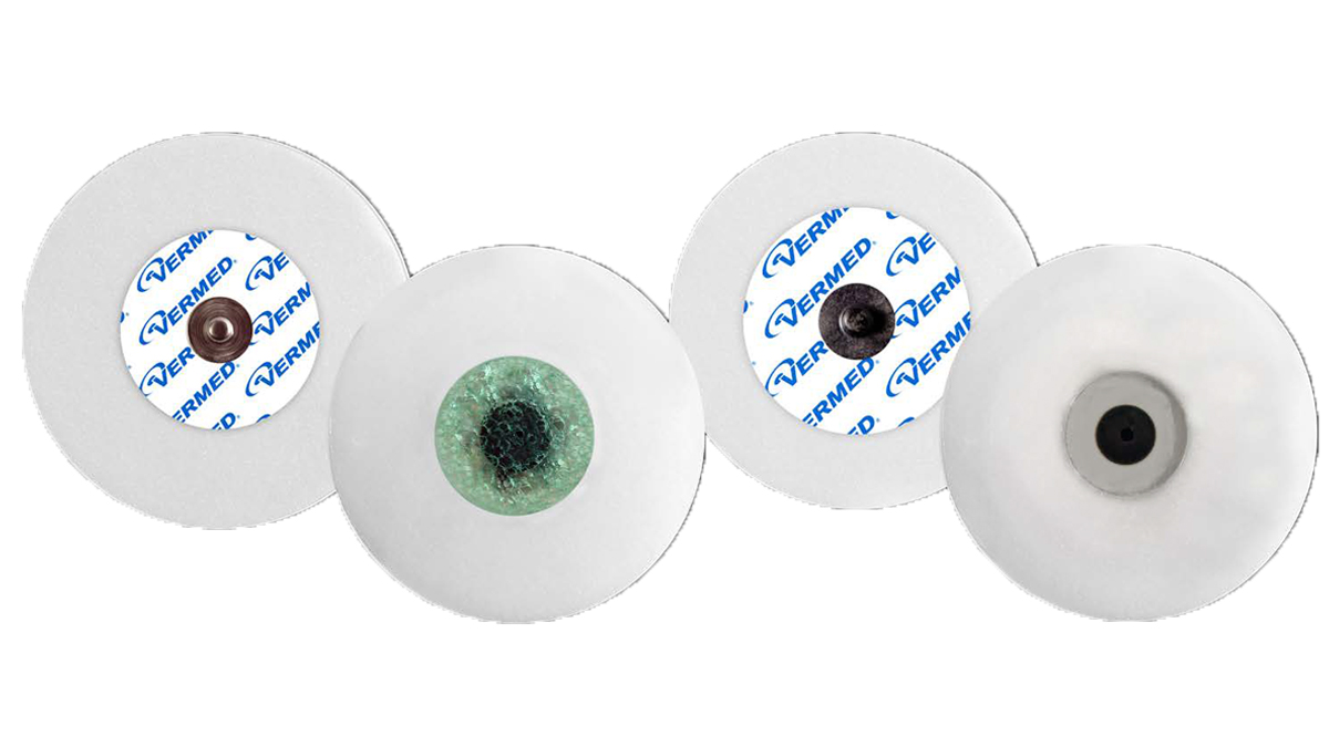 Fire runde elektroder til EKG med forskellige centre, nogle mærket med "VERMED".