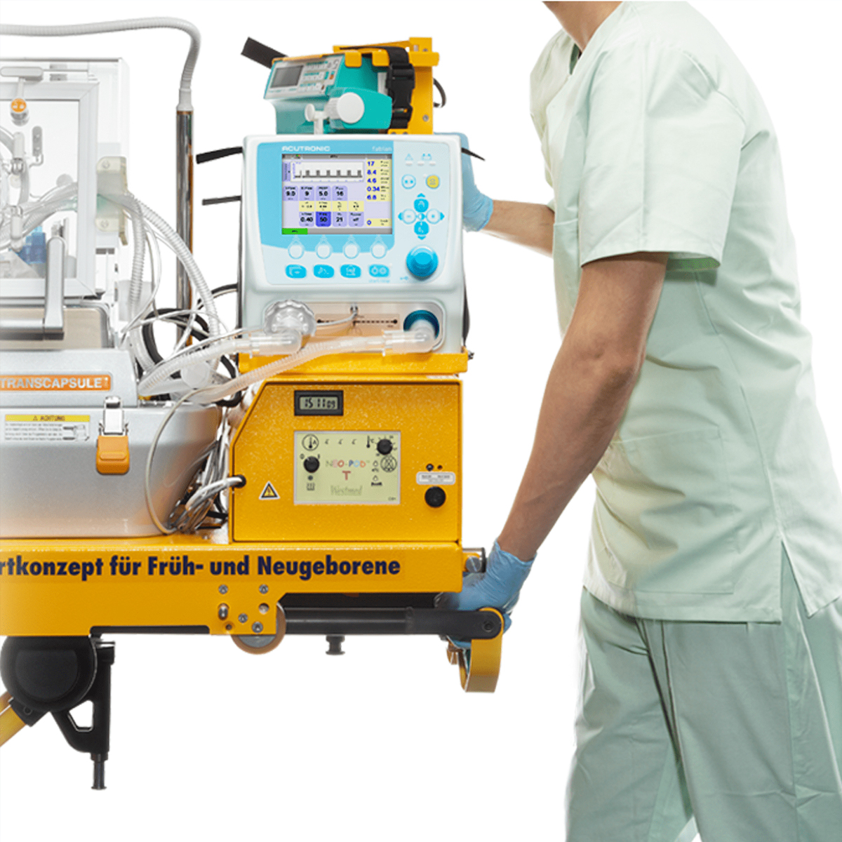 Sundhedspersonale i lysegrønt tøj håndterer medicinsk udstyr til spædbørn, herunder en kuvøse og overvågningsskærm.