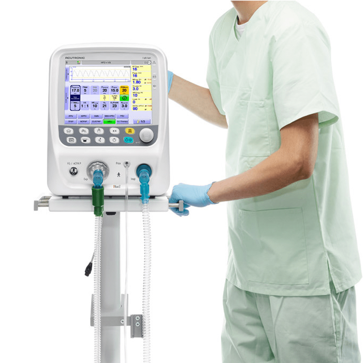 Person i lysegrøn uniform betjener en moderne respirator med digital skærm og tilsluttede slanger.