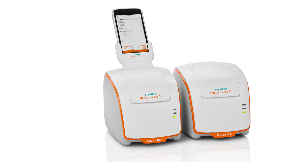 To hvide Siemens Healthineers Atellica DCA-enheder, den venstre med smartphone ovenpå.